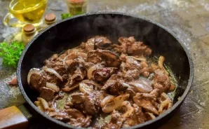 Heat the oil in a pan, put the liver and onion. Bake for 10-12 minutes, stirring so that they do not burn.