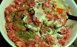 Mix the onion and meat, add a spoonful of sour cream, salt, pepper, marjoram and mix everything thoroughly (with your hands).