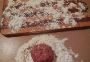 Sprinkle the table with flour. Form balls from minced meat and roll them in flour.