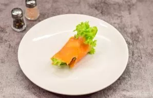 We roll the salmon so that the filling of the leaves and cucumbers is inside.