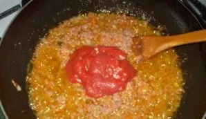 When the mince is already fried, we add salt, ground pepper and tomato paste. We stir and fry for a couple of minutes.
