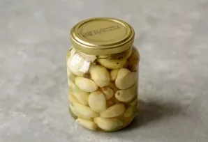Transfer the garlic cloves to a pre-sterilized jar. Pour the marinade, close the lid, turn it over and wrap it in a towel. Leave until co...