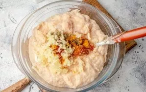 Put the mince in a suitable container, add garlic, spices, salt and black pepper squeezed through the press, mix the minced meat well.