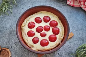 Cut the cherry tomatoes in half and put them on top of the cake.
