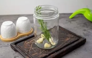 In a suitable container for oil, put a couple of cloves of garlic, and fresh rosemary - 1-2 sprigs.