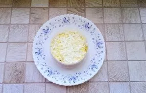 Boil the eggs hard, cool, peel and grate. Lay out the next layer.