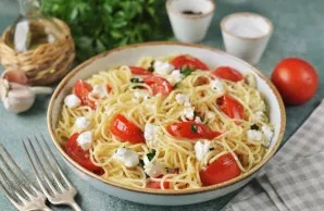 Now transfer the spaghetti to a bowl, slice the feta on top and mix gently again.