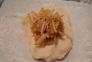 I tear off the pieces from the dough, knead each with my hands into a small flat patty, in the middle of which I put a grated apple and s...