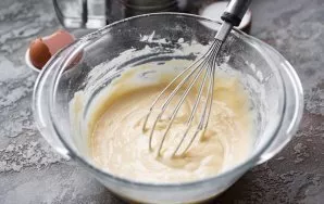 Knead the dough, the consistency of which resembles a thick pancake dough.