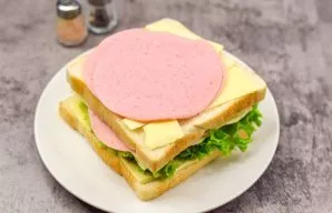 Cover everything with a second slice of bread, anointed with butter. Add sausage.