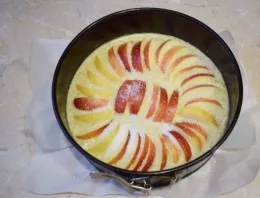 Cut the apples into slices and spread over the entire surface of the cake. Sprinkle the top of the cake with a little sugar. Place the ca...