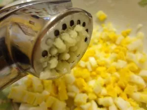 Peel the garlic and squeeze the press. Add to the eggs.