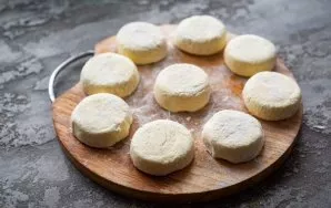 Then, with moistened hands, separate a small part (weighing about 30 grams) from the whole mass and form curds. Roll each pancake in flour.