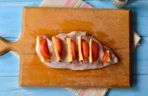 Put a piece of tomato and hard cheese in each cut.