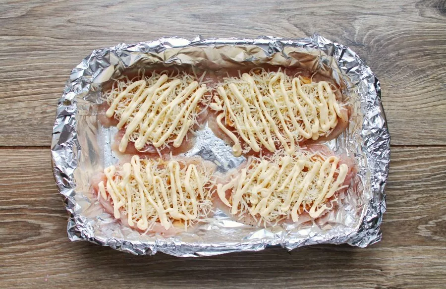 Spread mayonnaise on top of the cheese.