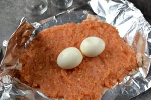 Put spices on the skin, evenly distribute the minced meat, lay boiled eggs in the middle.
