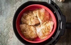 Put the marinated chicken thighs in a silicone mold, which is placed in the bowl of the air fryer. Put the bowl of the air fryer in the h...