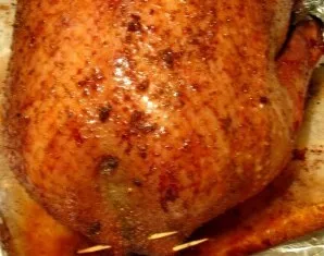 We stuff the goose with prunes and apples. With wooden toothpicks, we pin the skin to the neck and tail. Put on a greased baking sheet an...