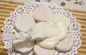 Place the marshmallows in one layer on the bottom of the prepared form. Grease it with cream, including the sides.