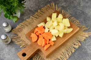 Strain the broth through a sieve, add chopped potatoes and carrots to it. Boil vegetables for 10 minutes.