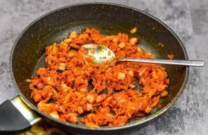 Next, pour tomato paste and suneli hops into the pan, mix everything and transfer everything from the pan to the pot.