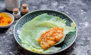 On the edge of the cabbage leaf put a few tablespoons of the filling of minced meat.