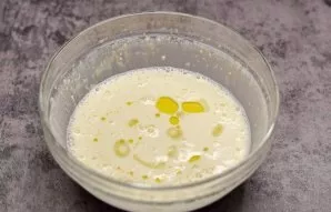 Pour in the oil and stir, let the dough rest a little, for a few minutes. At this time, heat the pan well.