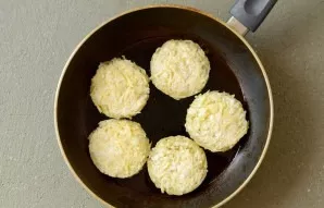 Heat the pan with oil over medium heat. Lay out the dough and fry the potato pancakes on both sides until golden brown.