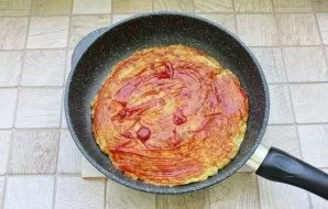 Remove the pan from the stove and coat the pizza with ketchup or any other tomato sauce.