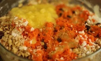 Sift the flour with baking powder. Add nutmeg and cinnamon. Mix grated carrots with dry ingredients and egg. Add dried raisins, pineapple...