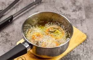 Gradually put the onion rings in oil, fry for 1.5 minutes. When the onion rings become golden in color, carefully remove from the oil wit...