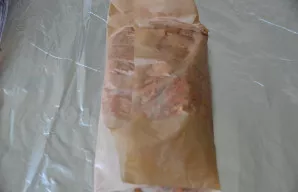 First, wrap the meat in baking paper.