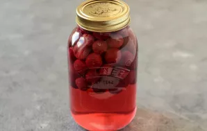 Add lemon juice to the jar. Cover the cherries with sugar and water syrup. Close the lid. Store in a cool, dark place for a couple of weeks.