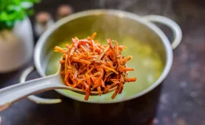 When the rice and vegetables are ready, add Korean carrots and spices to taste to the pan, fry. Then add to the soup and cook for 8-10 mi...