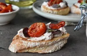 In a dry frying pan, fry the slices of bread, apply a thick layer of spread. Add slices of sun-dried tomatoes and fresh basil. And enjoy ...