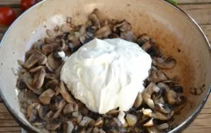 Fry the chopped champignons and onions until half-cooked, pour sour cream, mix and simmer until the mushrooms are browned.