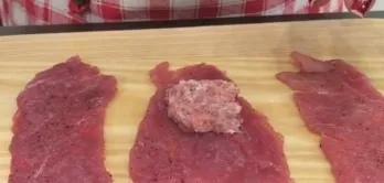 Put a few pieces of meat on the table and in small portions begin to put the filling inside. Gently fold the meat and wrap the roll in on...