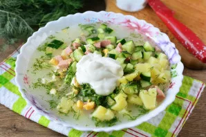 Pour cucumber marinade into the okroshka, add sour cream. Add water to taste, I added 150 grams of cold water. Stir.