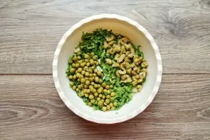 Cut the olives into pieces and put them together with the peas in the salad.