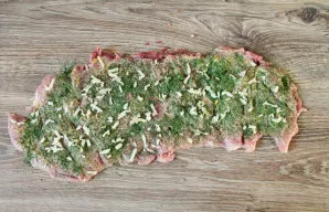 Peel the garlic, coarsely grate it and sprinkle it over the meat.