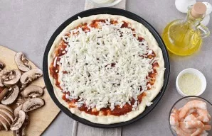 Spread the sauce liberally on the dough and sprinkle with grated mozzarella, leaving a couple of spoonfuls.