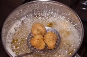 Immerse the mushrooms in boiling oil and fry until golden brown.