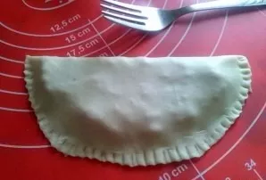 Place a spoonful of minced meat on one side of the dough pancake, cover with the other side. Firmly press the edges of the cheburek with ...