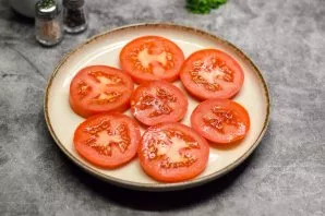 Wash and dry the tomatoes. Cut the tomatoes into slices. Put slices of tomatoes on a plate.
