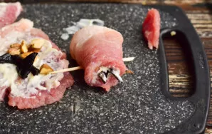 Roll the meat into rolls, fix each with a toothpick.