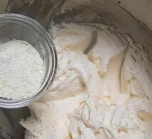 Add milk powder and half a cup of coconut to the mixture. Mix well.