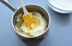 Pour the egg yolks whipped with sugar into the still hot rice base and stir intensively until smooth.