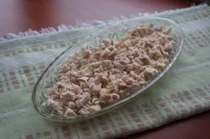 Finely chop the chicken meat and add it to the salad bowl. Pour mayonnaise over the layer.