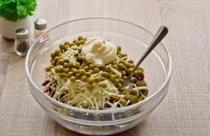 Add mayonnaise to the salad. Peel and grate a clove of garlic and add to the salad. Add salt and pepper to taste.