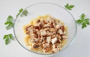 Fry the chicken fillet over low heat on both sides until cooked and chopped with a knife. Put in a bowl with pasta.
